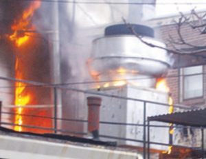 A commercial kitchen's rooftop exhaust fan on fire